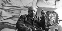 Pablo Picasso em Paris, no ano de 1950, sentado em frente a suas obras.  Foto: Sanford Roth/Getty Images / Guia do Estudante