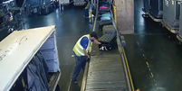 Imagens de câmeras de monitoramento exibidas pela TV Globo flagraram o momento em que dois funcionários do aeroporto trocaram as etiquetas das malas de duas brasileiras  Foto: Reprodução/TV Globo