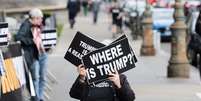 Do lado de fora do tribunal, em Nova York, mulher mostra cartaz: 'Onde está Trump?'  Foto: EPA-EFE/REX/Shutterstock / BBC News Brasil