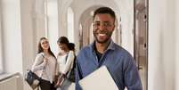 positivity-african-student-wearing-shirt-holding-notes.jpg  Foto: banco de imagens 