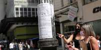 Mulheres olham anúncios de emprego afixados em poste de luz no centro de São Paulo   Foto: REUTERS/Amanda Perobelli