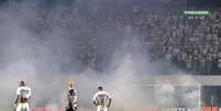 Roj&otilde;es atirados pela torcida do Santtos dificultaram a sa&iacute;da dos jogadores na Vila Belmiro &ndash;  Foto: Reprodu&ccedil;&atilde;o/Premiere / Jogada10