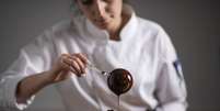 Chef coloca calda de chocolate em bolo  Foto: iStock