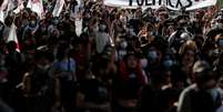 Manifestantes seguram cartaz com linguagem neutra em protesto no Chile  Foto: AFP / BBC News Brasil