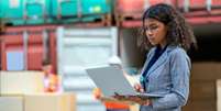 Uma mulher usando um laptop em um porto  Foto: Getty Images / BBC News Brasil