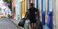 Homem carrega saco com latinhas de alumínio em Olinda  Foto: Marlon Costa/Futura Press