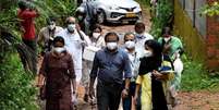 Integrantes de uma equipe médica da Faculdade de Medicina de Kozhikode carregam amostras de noz de areca e goiaba para realizar testes para o vírus Nipah na Vila de Maruthonkara, no distrito de Kozhikode, em Kerala, na Índia.  Foto: Stringer/Reuters