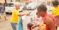 Frame da reportagem "Contos verdade com Tialila" mostra a ativista Rita Santa Rita distribuindo jornal do Grupo de Mulheres do Alto das Pombas (GRUMAP), em Salvador (Foto: Reprodução)  Foto: Alma Preta
