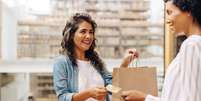 Cliente feliz pagando com um cart&atilde;o de cr&eacute;dito em uma loja de cer&acirc;mica   Foto: Foto: Istock