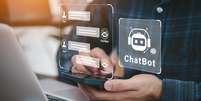 Homem utilizando o sistema AI Chatbot no computador ou aplicativo móvel  Foto: Foto:Istock