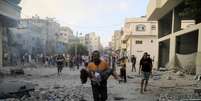 Homem palestino carrega criança após ofensiva israelense contra palestinos na Faixa de Gaza  Foto: REUTERS/Yasser Qudih