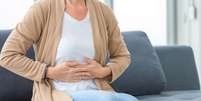 Imagem meramente ilustrativa de uma mulher com dor abdominal  Foto: iStock