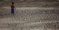 País enfrenta crise climática com queda de orçamento previsto para o Meio Ambiente. Em Manaus, um menino caminha pelas redondezas do Rio Negro, que atingiu sua maior seca em 121 anos  Foto: Reprodução/REUTERS/Bruno Kelly