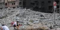 Palestino lava as mãos em uma poça ao lado de um prédio destruído após os ataques israelenses na Cidade de Gaza  Foto: hmed Zakot/SOPA Images/LightRocket via Getty Images