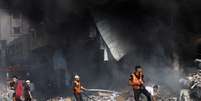 Bombeiros palestinos trabalham em prédio atacado por Israel em Khan Younis  Foto: REUTERS/Mohammed Salem