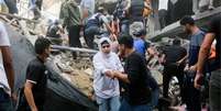 Palestinos procuram vítimas em local de ataque israelense, no sul da Faixa de Gaza  Foto: Reuters / BBC News Brasil