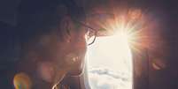 Homem olhando atrav&eacute;s de janela de avi&atilde;o   Foto: Getty Images / BBC News Brasil