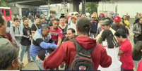 Na confusão, um passageiro chega a arremessar o celular de uma manifestante no chão  Foto: Reprodução/ TV Globo