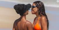 Ludmilla e Brunna Gonçalves trocam beijos na praia.  Foto: AGNews / Purepeople