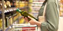 Mulher escolhe azeite no supermercado  Foto: iStock