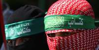 Abu Ubaida usando um keffiyeh vermelho na cabeça que mantém sua identidade em segredo  Foto: Getty Images / BBC News Brasil