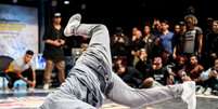 Imagem mostra um jovem negro no chão em competição de break dance  Foto: Alma Preta