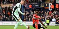  Foto:   Ben Stansall / AFP  via Getty Images - Legenda: Broja (à direita) tenta sair da marcação dupla da defesa do Luton Town para seguir levando o Chelsea ao ataque / Jogada10