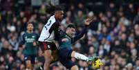  Foto: Adrian Dennis / AFP via Getty Images - Legenda: Gabriel Martinelli (à direita) tenta dominar a bola enquanto é bem marcado por  Iwobi, do Fulham  / Jogada10