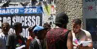 A imagem mostra um homem entrevistando pessoas em situação de rua.  Foto: Alma Preta