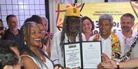 A imagem mostra o governador Jerônimo Rodrigues e representantes do concurso "Noite da Beleza Negra" segurando uma placa do processo de patrimonialização.  Foto: Alma Preta