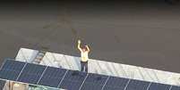 Morador pede ajuda em cima do telhado em bairro de Duque de Caxias  Foto: Reprodução/TV Globo