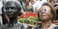 A imagem mostra a estátua de Enedina Alves ao lado de sua sobrinha, uma senhora negra. A foto foi tirada no dia da inauguração da escultura.  Foto: Alma Preta