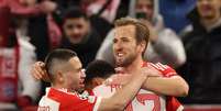 Harry Kane, Jamal Musiala e Raphaël Guerreiro comemorando o gol do Bayern de Munique.   Foto: Alexander Hassenstein/Getty Images / Esporte News Mundo