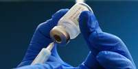 Mão com luva com frasco de vacina  Foto: PA MEDIA / BBC News Brasil