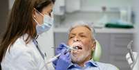 Homem idoso é avaliado por dentista  Foto: iStock