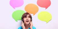 Uma criança com fones de ouvido que parece ouvir frases em idiomas diferentes  Foto: Getty Images / BBC News Brasil