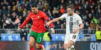  Foto: Jure Makovec/AFP via Getty Images - Legenda: Cristiano Ronaldo em disputa de bola com Timi Elsnik, da Eslovênia - / Jogada10