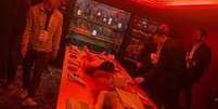 A imagem mostra um grupo de homens no quarto laqueado de vermelho do hotel cinco estrelas Mandrake, no centro de Londres, com um homem e uma mulher parcialmente nus, deitados imóveis na mesa à sua frente.  Foto: Reprodução