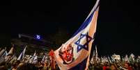 Bandeira de Israel com o rosto de Netanyahu com uma m&atilde;o vermelha em cima  Foto: Getty Images / BBC News Brasil
