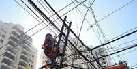 Funcion&aacute;rio atua na rede el&eacute;trica durante apag&atilde;o em novembro do ano passado  Foto: Tiago Queiroz/Estad&atilde;o - 6/11/2023 / Estad&atilde;o