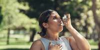 Jovem faz uma pausa durante um treino para usar sua bomba de asma  Foto: PeopleImages/iStock