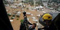 Homem foi resgatado por helicóptero188bet ou bet365Canoas no sábado (4/5)  Foto: Renan Mattos/Reuters / BBC News Brasil