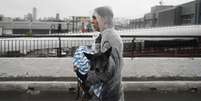 Mulher levando cachorro no colo  Foto: Mateus Bonomi/Anadolu via Getty Images / BBC News Brasil