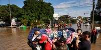 Resgate em Porto Alegre: desastres ambientais causam sequência de danos variados, da saúde à infraestrutura  Foto: Reuters / BBC News Brasil