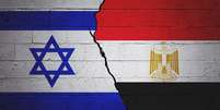 Bandeiras de Israel e do Egito pintadas em um muro com rachadura no meio  Foto: Getty Images / BBC News Brasil