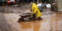 Homem limpa casa inundada em Muçum; contato com a água ou lama em enchentes pode causar doenças  Foto: DW / Deutsche Welle