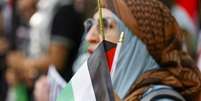 Uma mulher com a bandeira palestina no Texas   Foto: EPA / BBC News Brasil