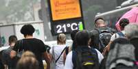 Pedestres se protegem do frio e de leve garoa na Avenida Paulista, na região central de São Paulo, no dia 14 de maio de 2024.  Foto: RONALDO SILVA/ATO PRESS/ESTADÃO CONTEÚDO