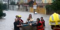 Socorristas resgatam família durante enchente em Porto Alegre, no Rio Grande do Sul  Foto: REUTERS/Diego Vara