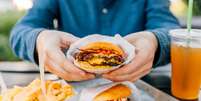 Dois hambúrgueres, com batata e refrigerante ao lado, uma combinação clássica e deliciosa.  Foto: Alexander Spatari / Getty Images